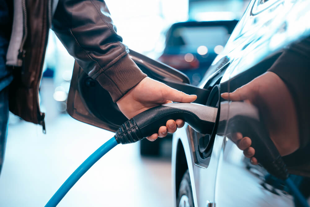 human hand is holding electric car charging connect electric car (1)